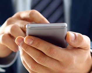 Um profissional de fato está a segurar um telemóvel.