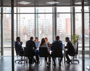 Uma equipa de profissionais a participar numa reunião dentro de um espaço de escritório.