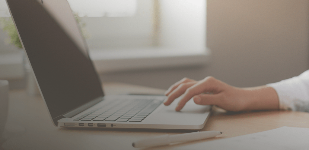 Close-up of a person’s hands typing on a laptop